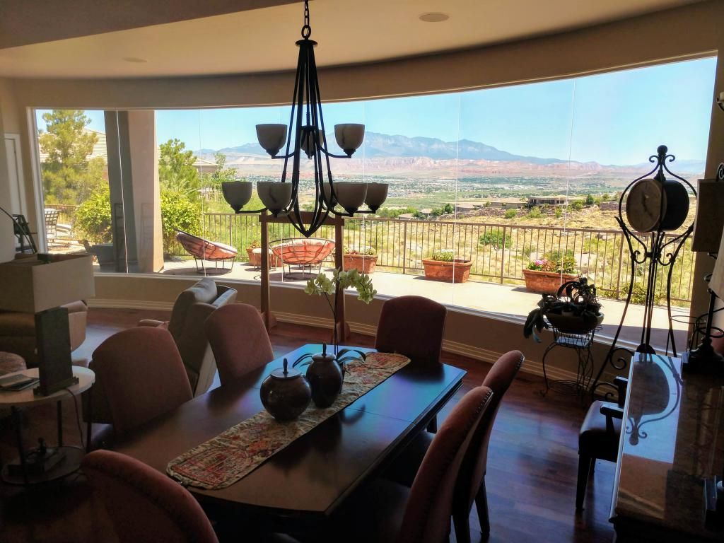 A dining room with a table and chairs and a view of the mountains