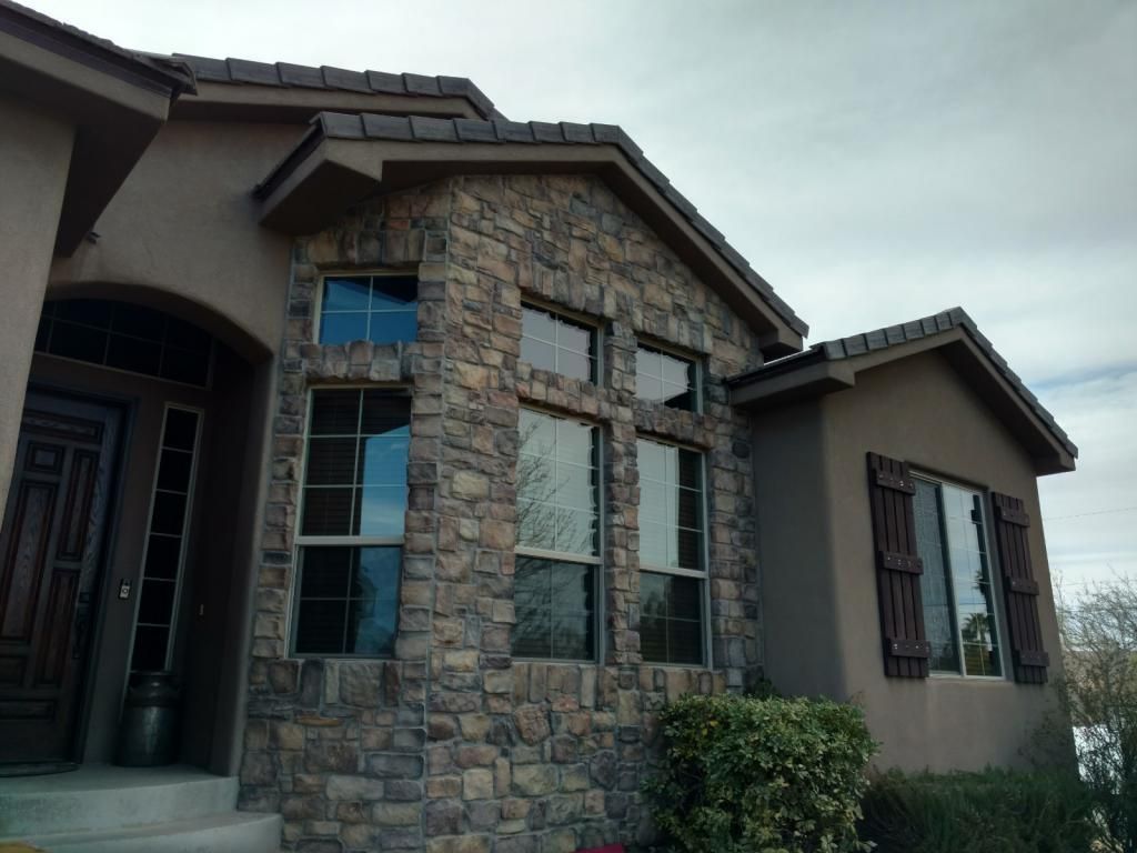 A large stone house with lots of windows and shutters