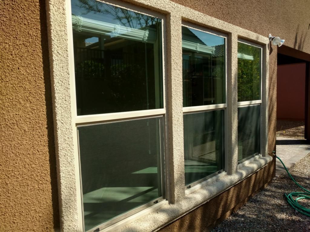 There are three windows on the side of a building.