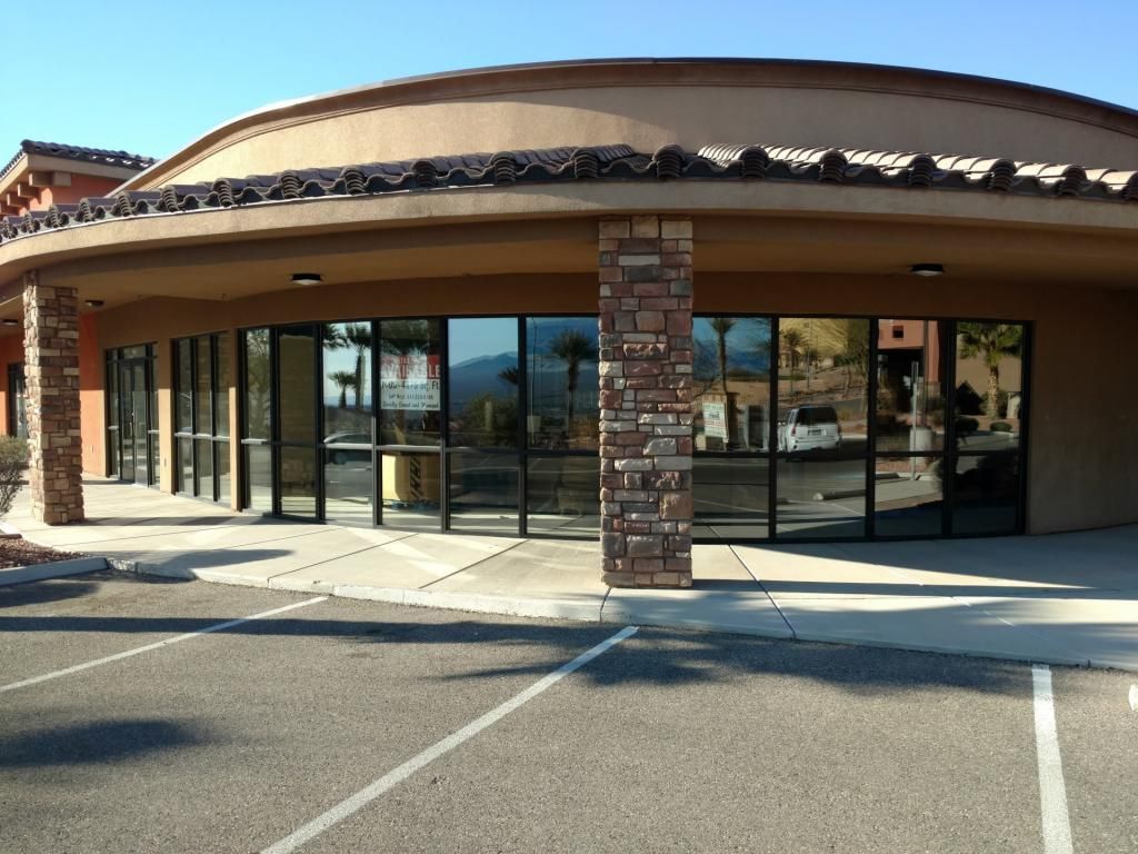 A building with a lot of windows and a parking lot in front of it