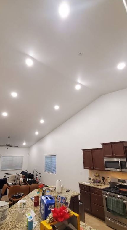 A kitchen with a vaulted ceiling and lots of lights on the ceiling.
