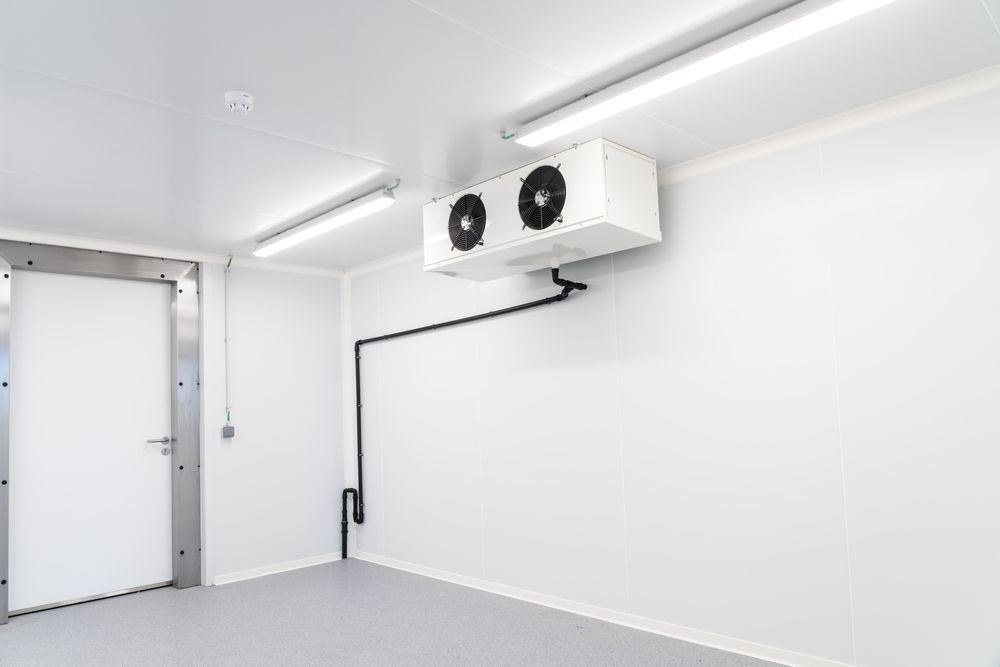 An Empty Room With Two Air Conditioners Hanging From the Ceiling — Hutchy's Refrigeration & Electrical in Torres Strait, QLD