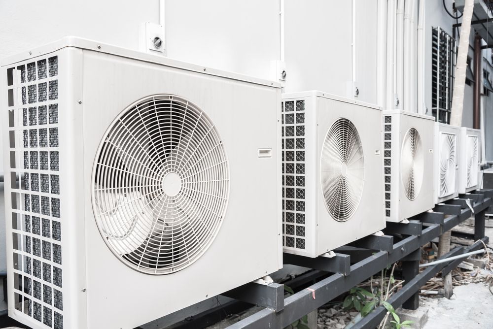 Outdoor Air Conditioning Units Lined Up Against a Wall — Hutchy's Refrigeration & Electrical in Tablelands, QLD
