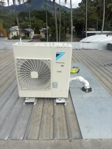 Daikin HVAC unit on a corrugated metal roof, with mountains in the background— Hutchy's Refrigeration & Electrical in Trinity Park, QLD