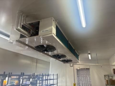 Ceiling-mounted industrial refrigeration unit in a cold storage room with multiple fans and ventilation — Hutchy's Refrigeration & Electrical in Trinity Park, QLD