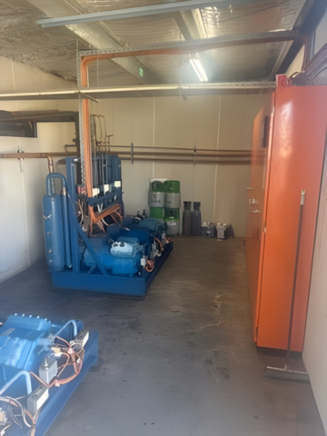 An Empty Refrigerator With Stainless Steel Shelves in a Kitchen — Hutchy's Refrigeration & Electrical in Trinity Park, QLD