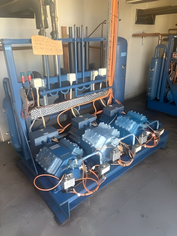 Blue industrial air compressor system. Multiple compressors, tanks, and tubing in a workshop — Hutchy's Refrigeration & Electrical in Trinity Park, QLD
