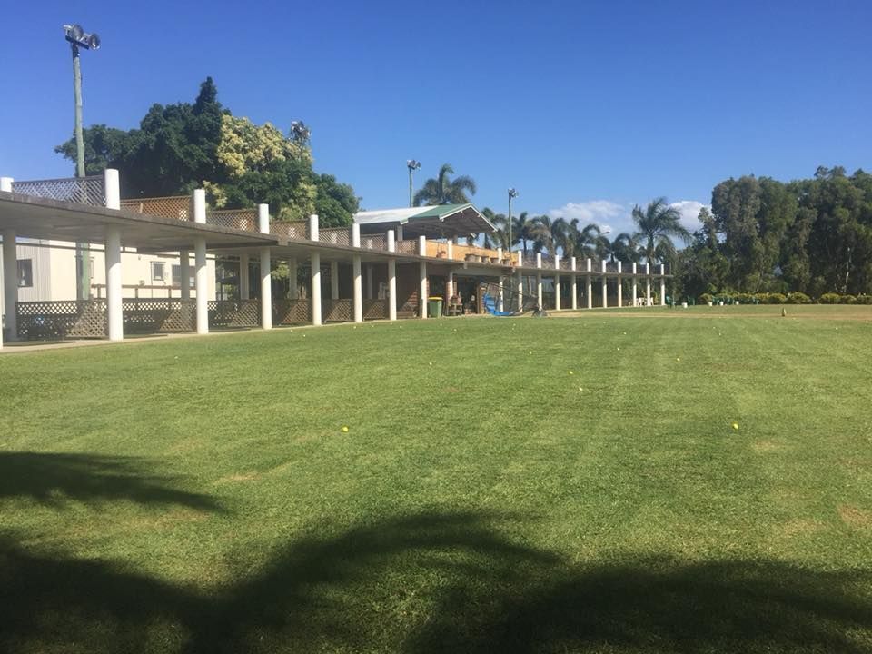 A large grassy field with a building in the background