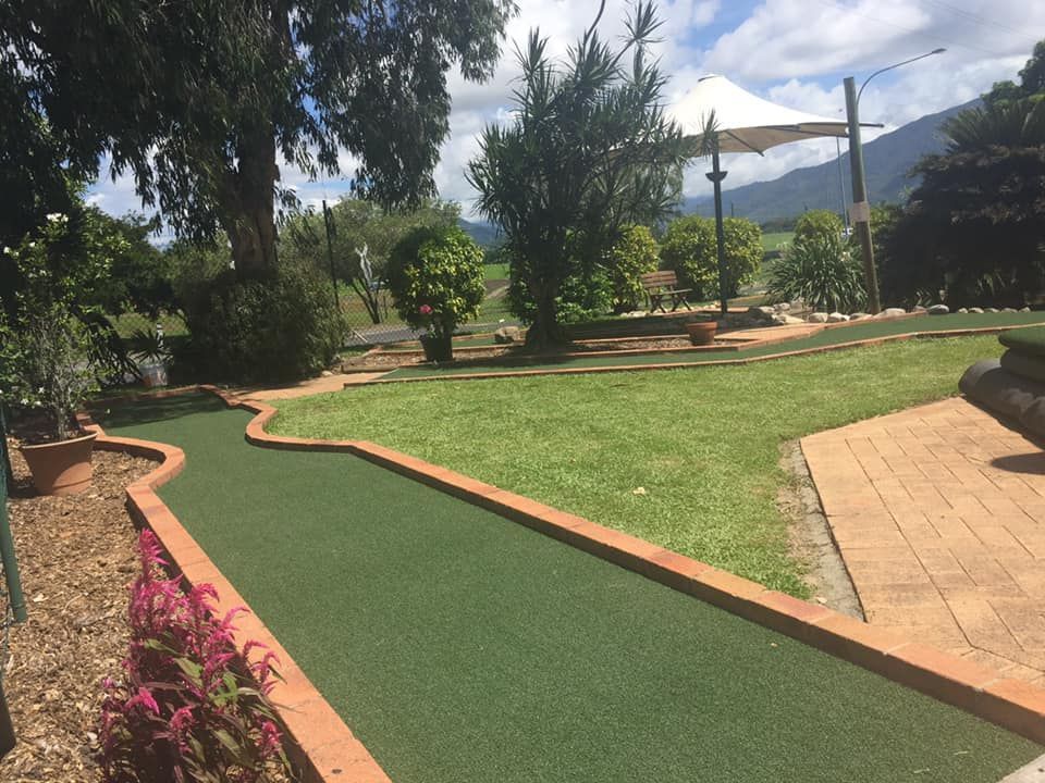 A small golf course in a park with mountains in the background