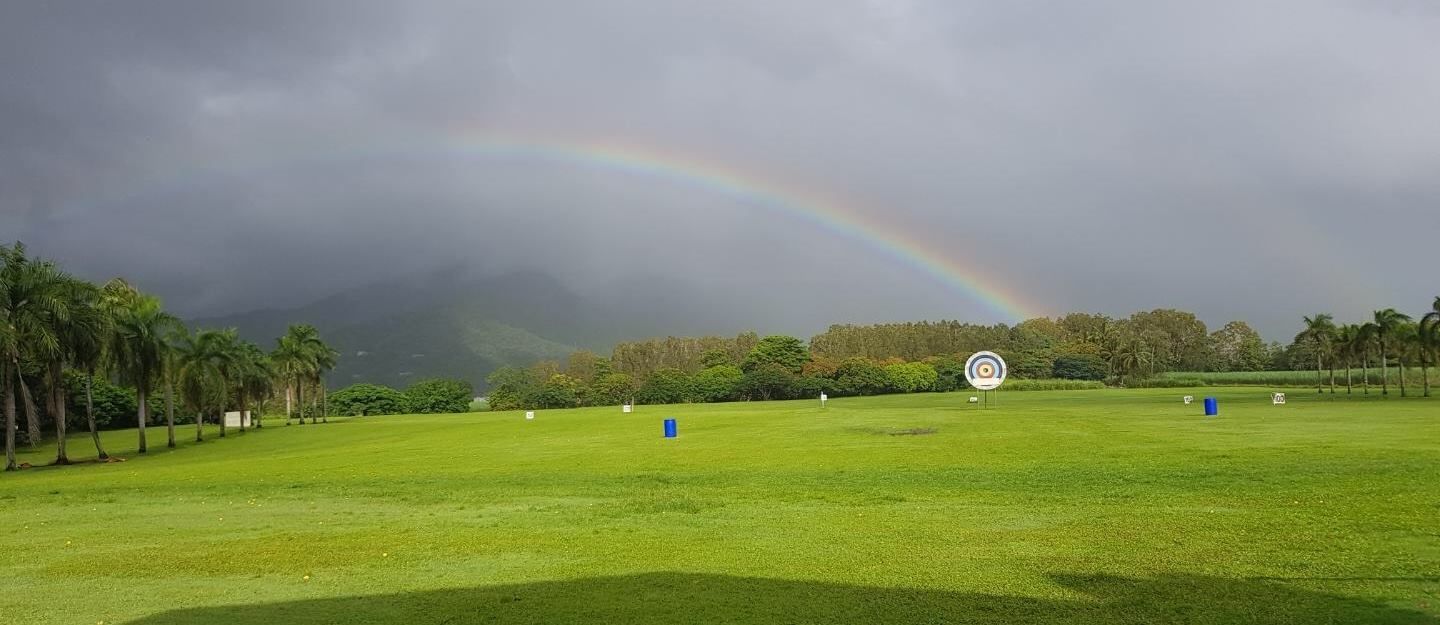 There is a rainbow in the sky over a golf course.