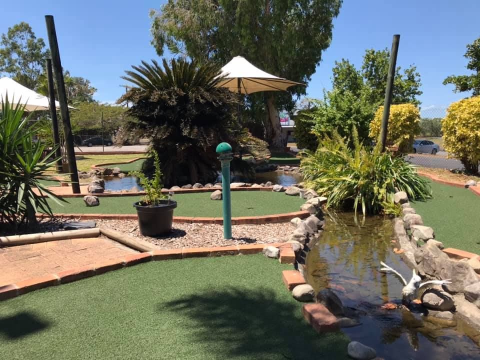 A golf course with a pond in the middle of it