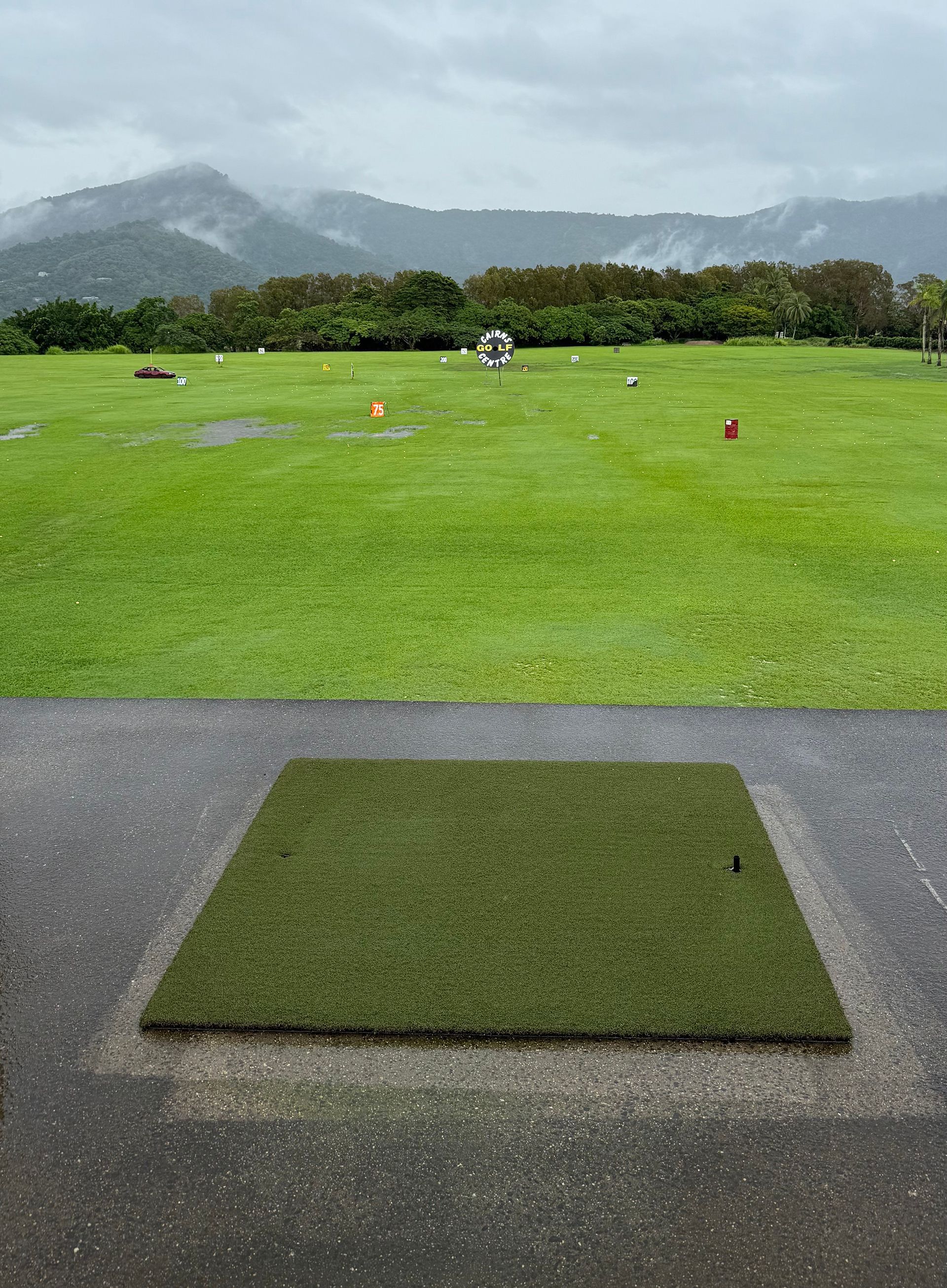 A golf course with mountains in the background and a mat in the foreground
