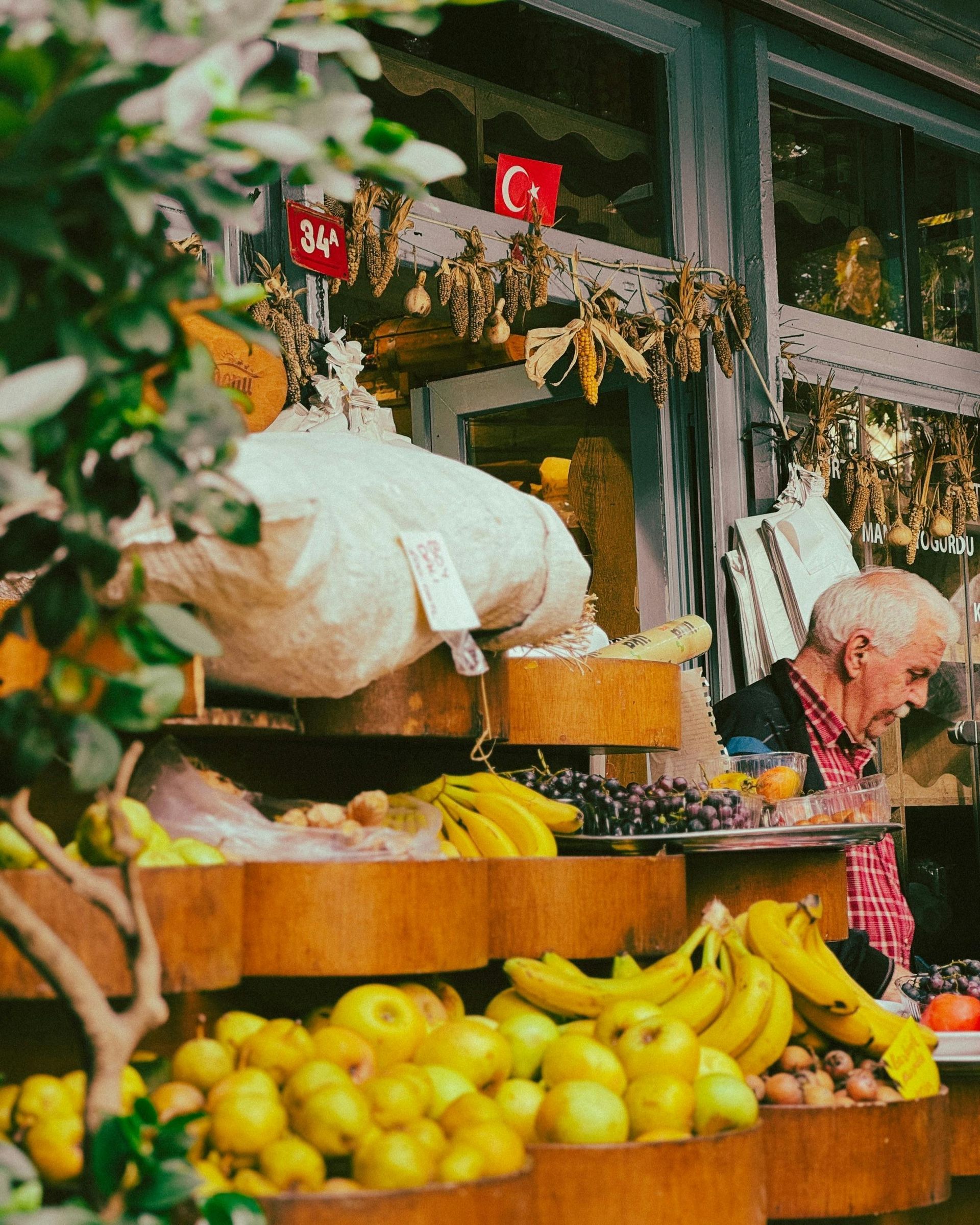 A man is standing in front of a display of fruits and vegetables.