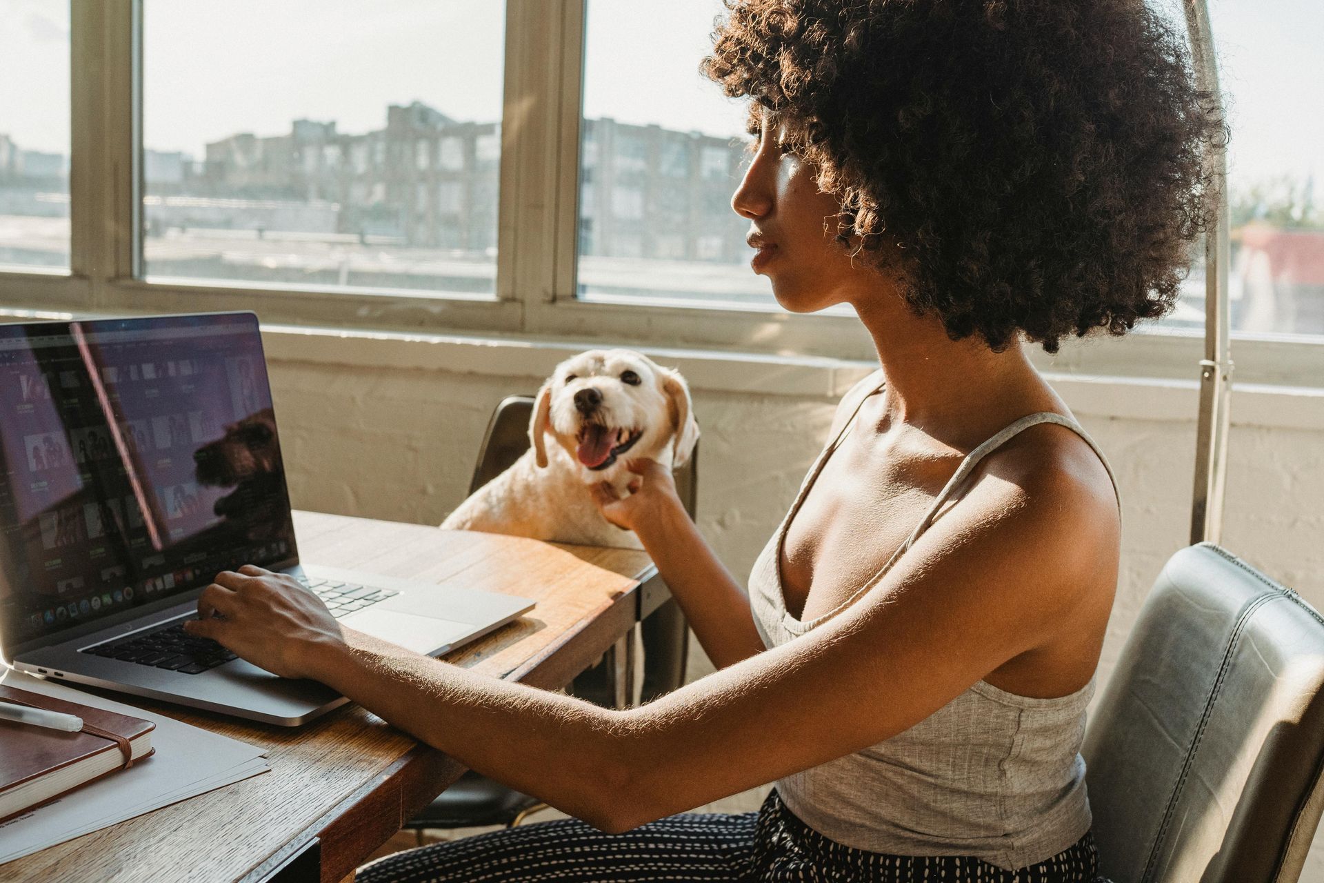 A woman is sitting at a desk using a laptop computer.
