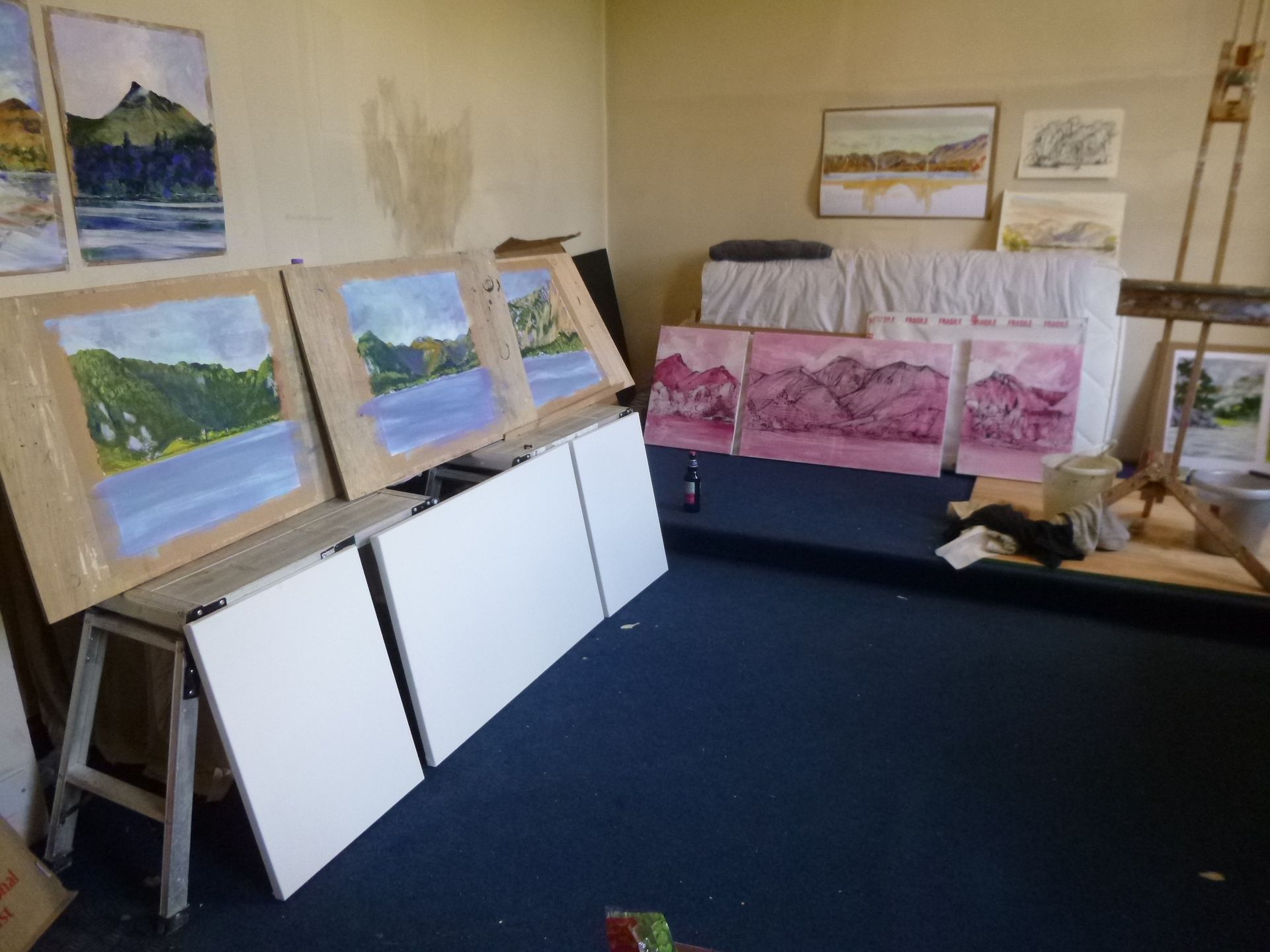 A room with a lot of paintings on the wall