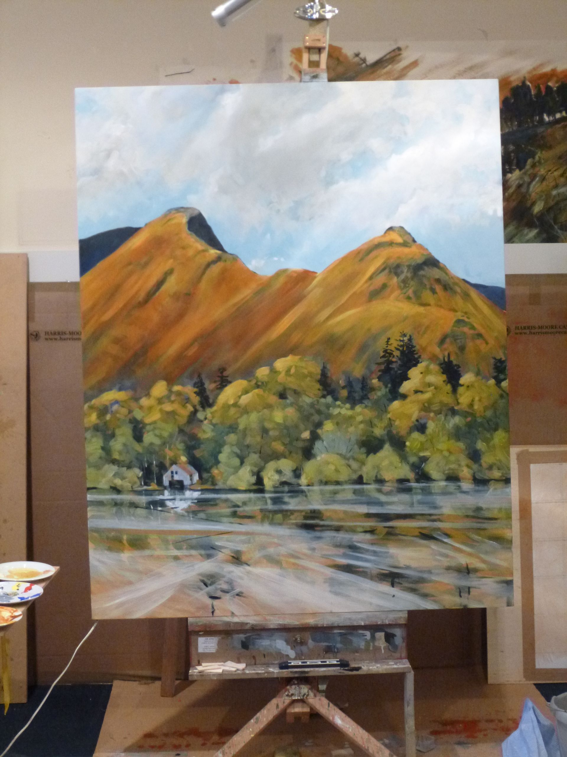A large painting of a lake with mountains in the background