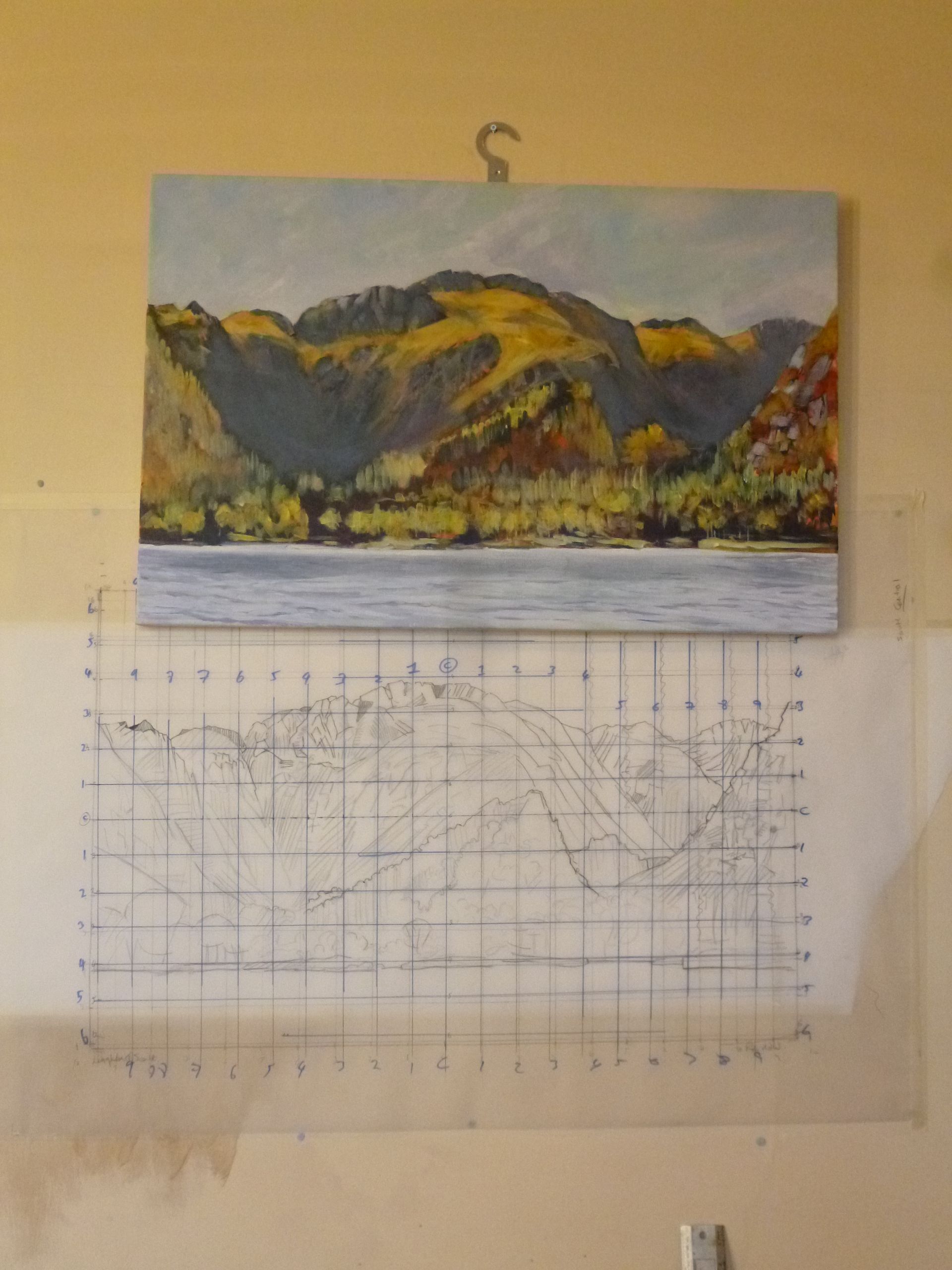 A painting of mountains and a lake is hanging on a wall