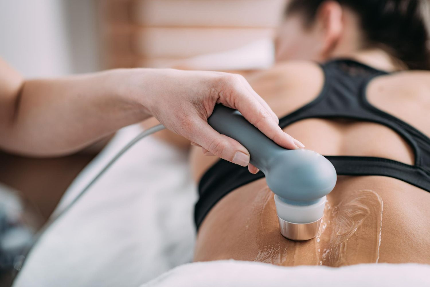A woman is getting an ultrasound treatment on her back.
