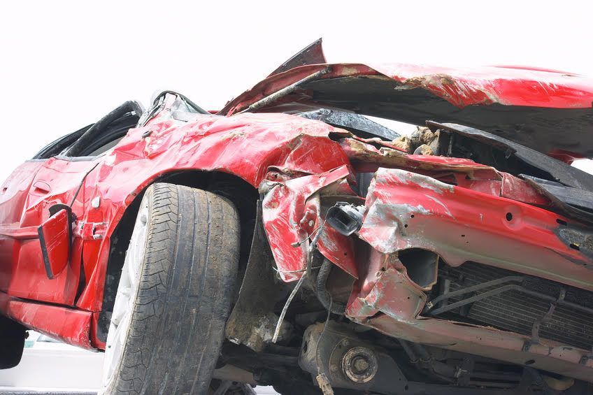A red car that has been damaged in a car accident.