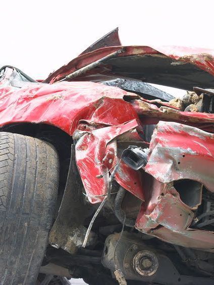 A crushed red car due to acident