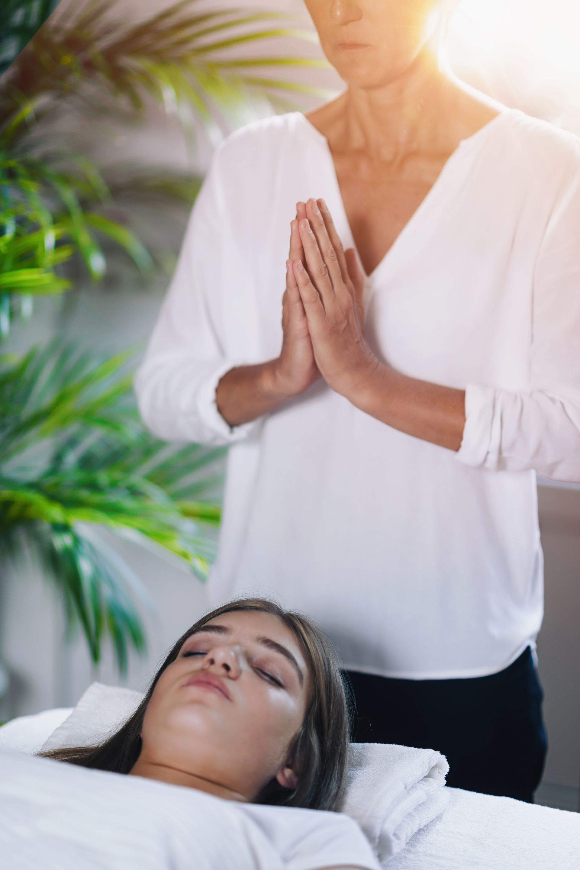 a woman is laying on a bed getting a reiki treatment .
