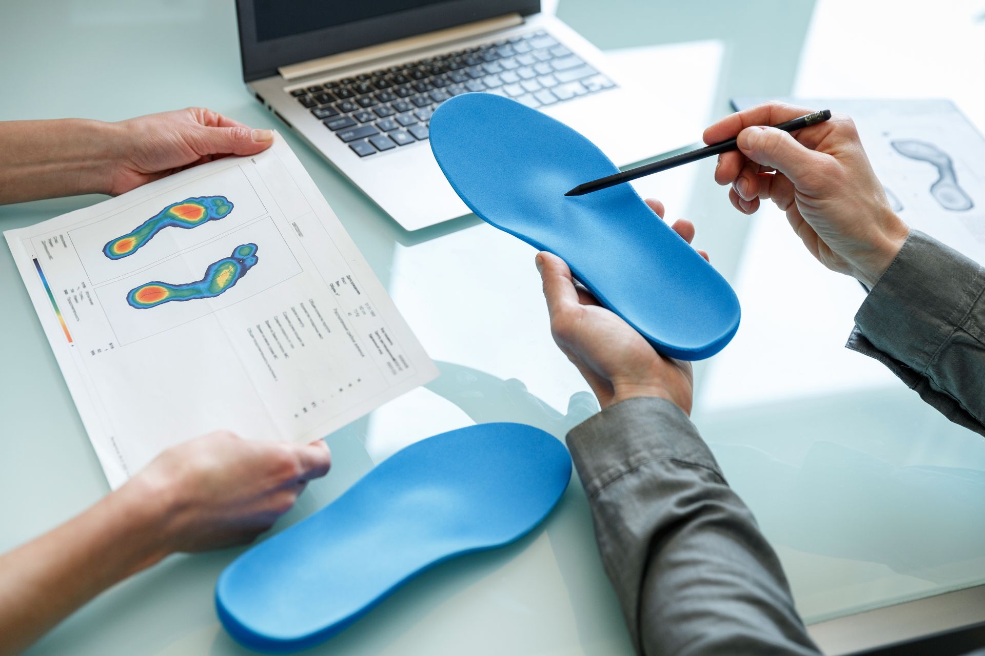 a person is holding a pair of blue insoles in their hands .