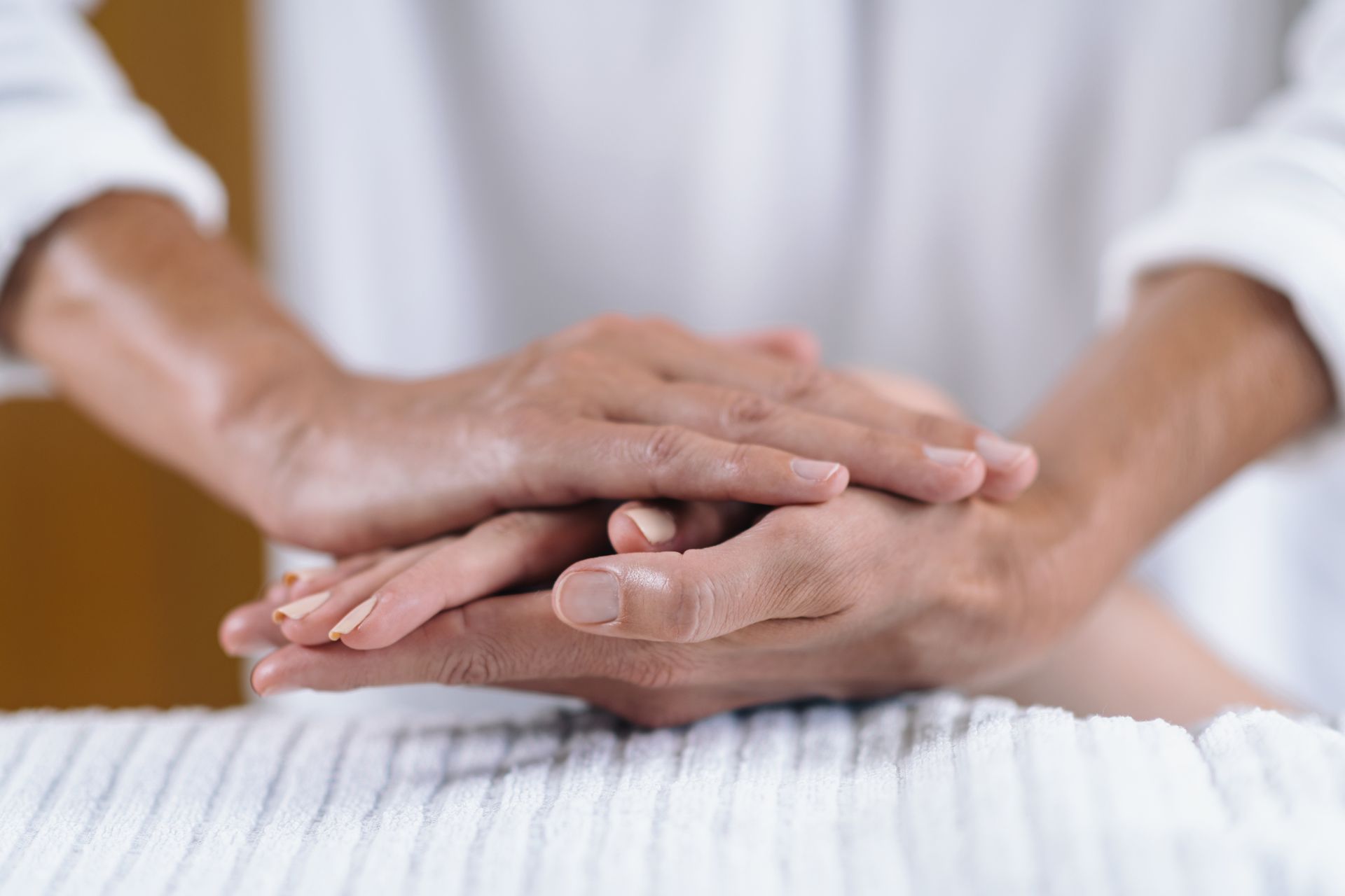 a close up of a person 's hands stacked on top of each other on a table .