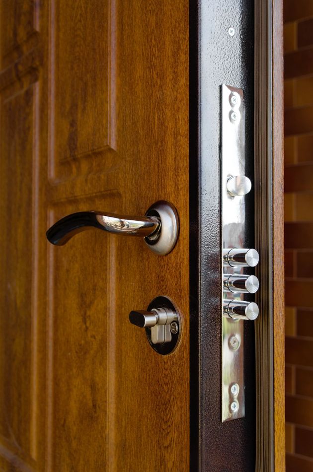 Porta marrone con maniglia argentata e sistema di sicurezza multi-lock.