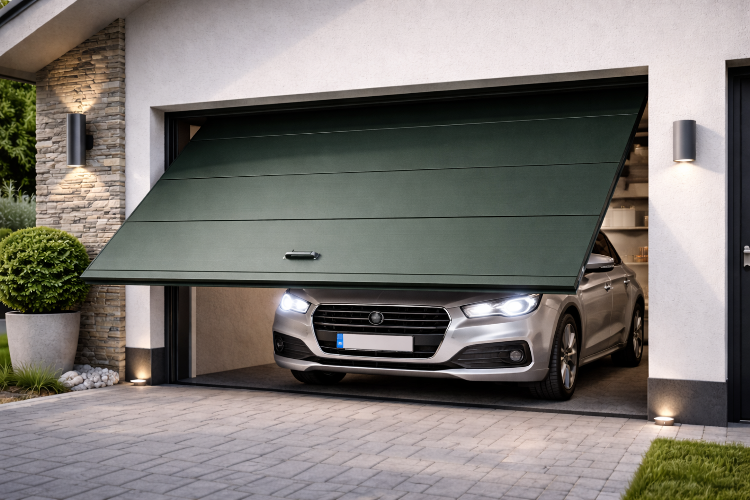 Apertura della porta del garage con un'auto argentata all'interno. Porta verde scuro, passerella in mattoni, luci esterne.
