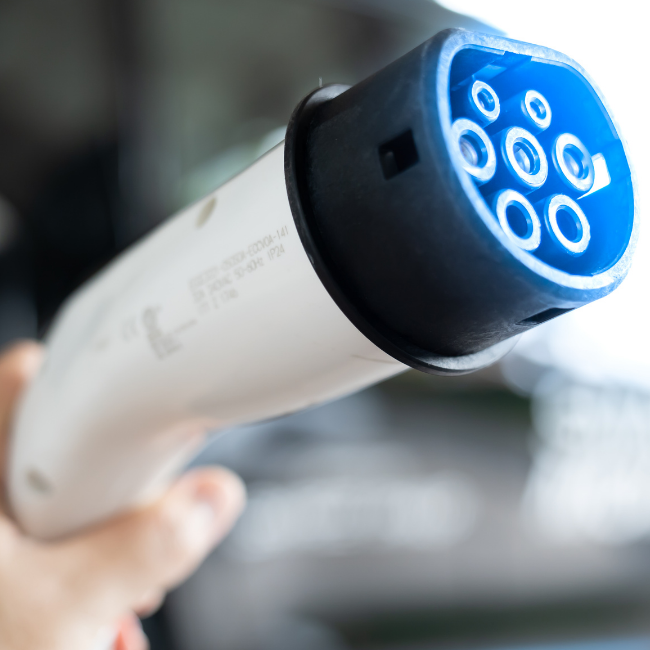 A close up of a person holding a charging cable