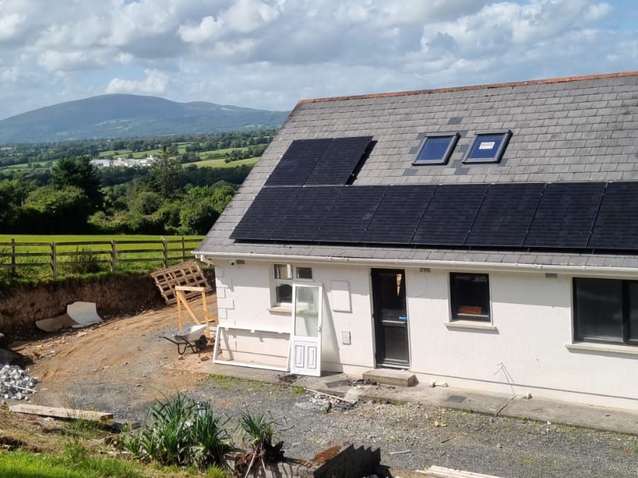 A white house with solar panels on the roof