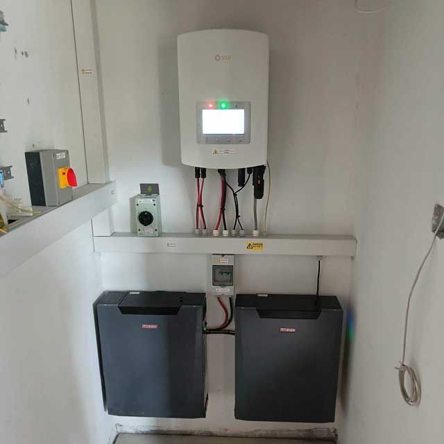 A room with two batteries and a solar panel on the wall.