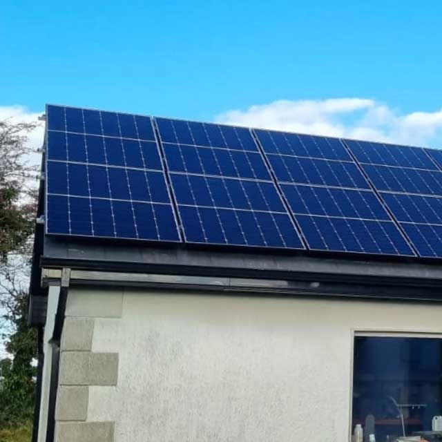 A white building with solar panels on the roof