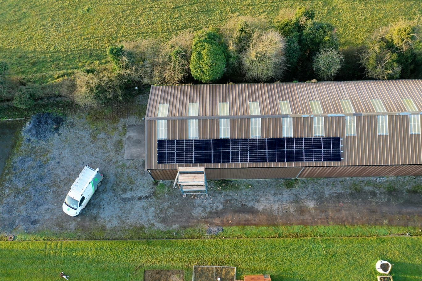 An aerial view of a building with solar panels on the roof.