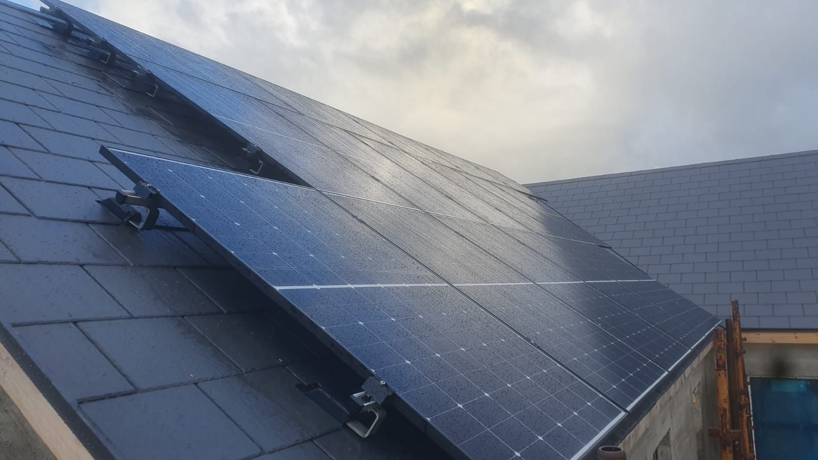 A row of solar panels sitting on top of a roof.