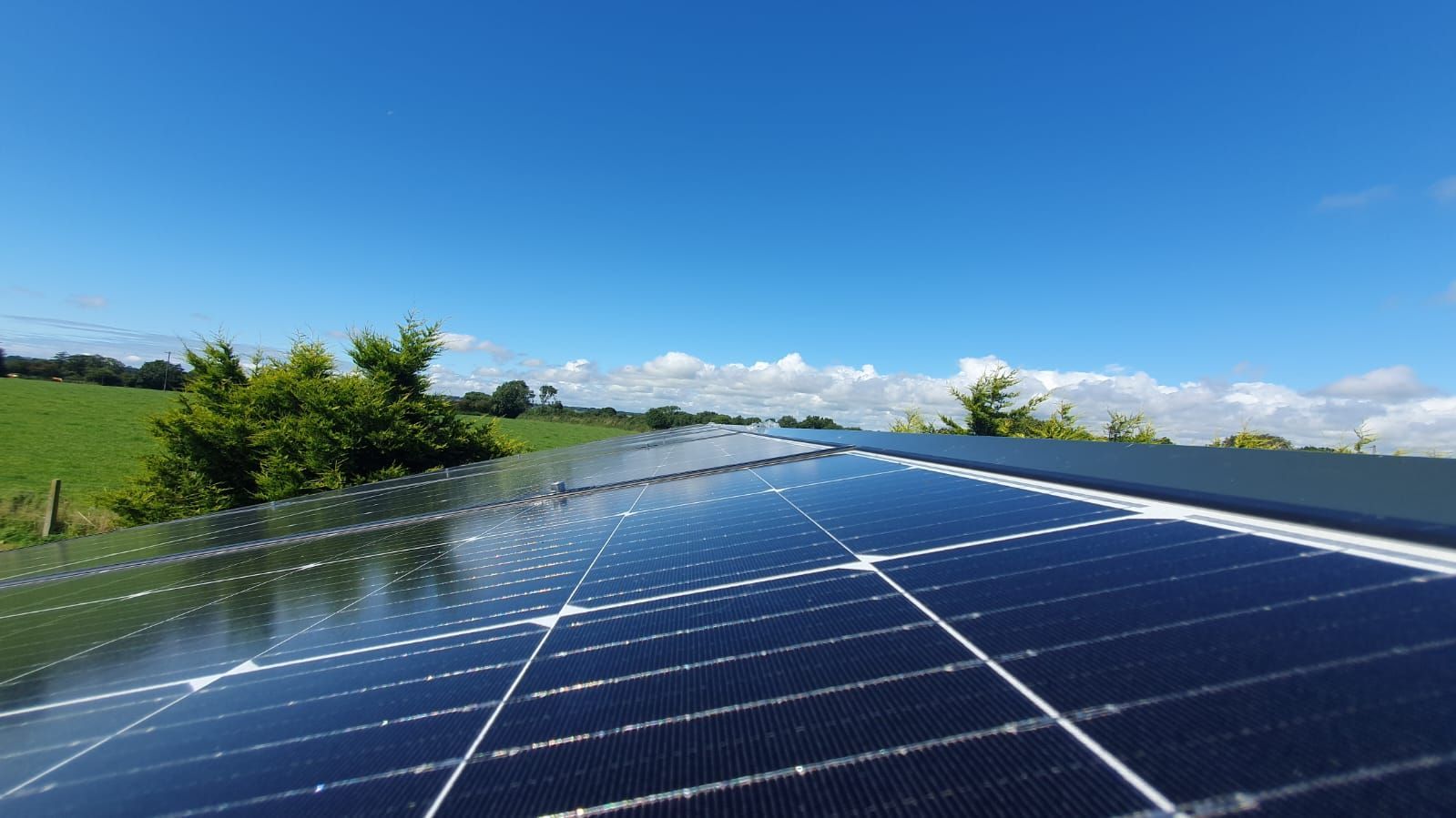 A row of solar panels sitting on top of a roof.