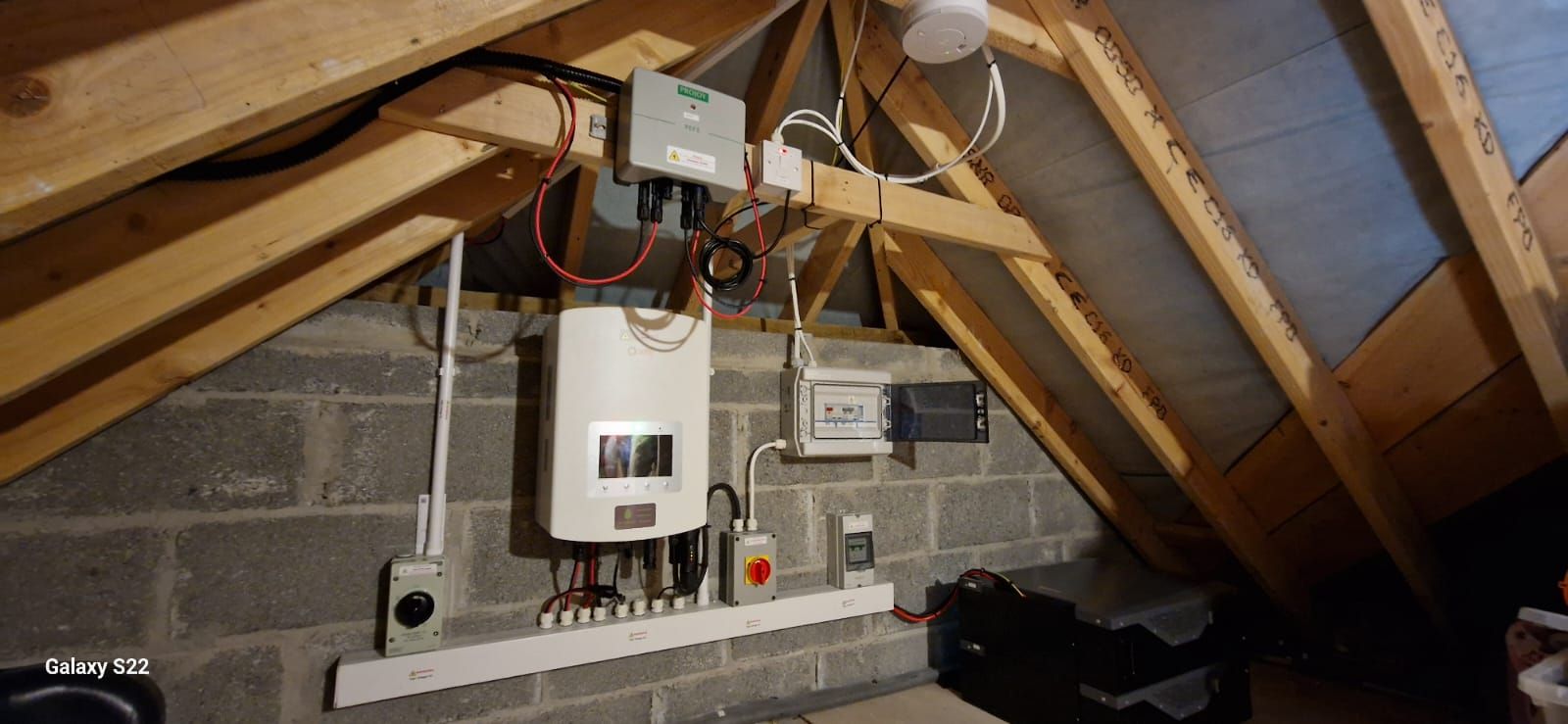 An attic with a lot of electrical equipment hanging from the ceiling.