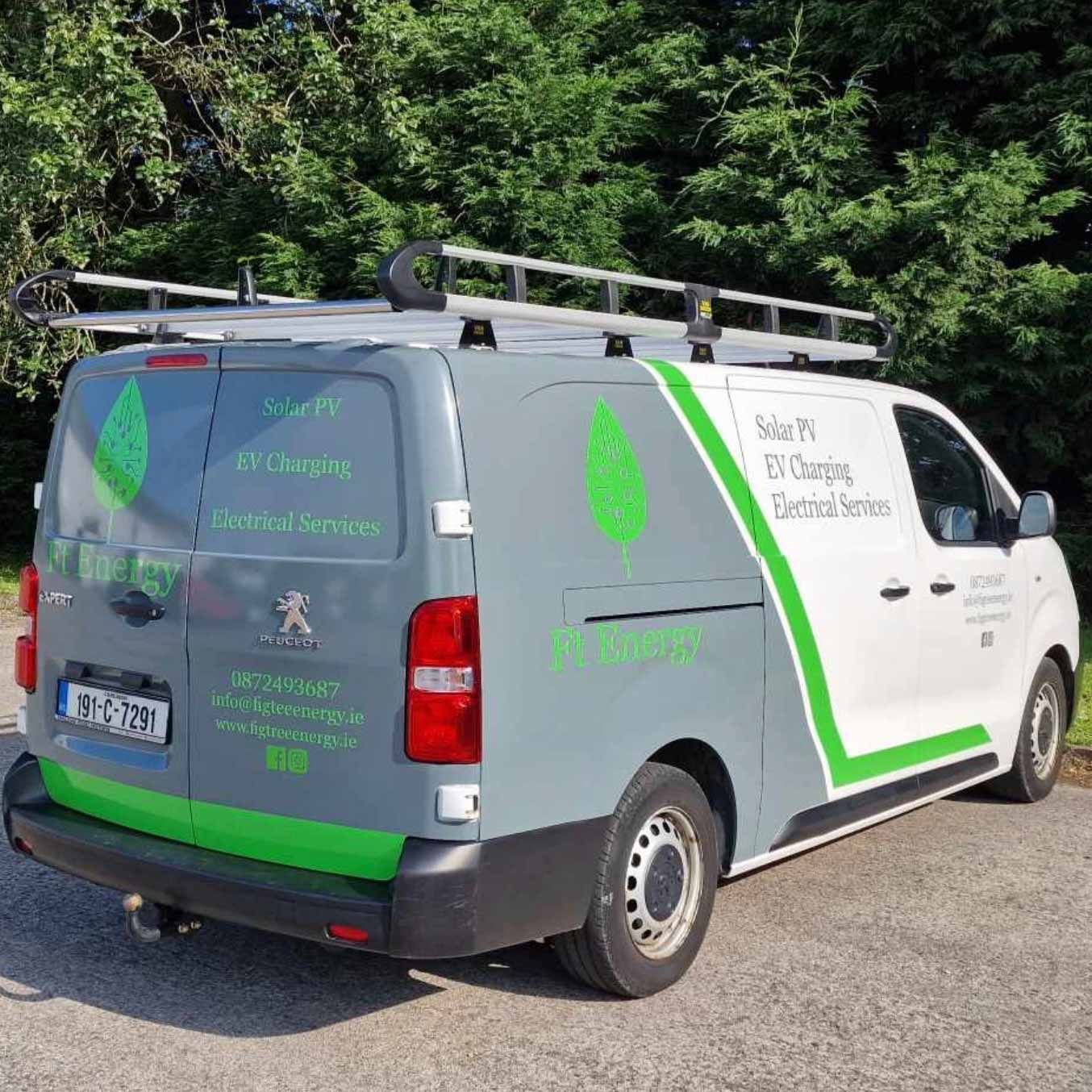 A gray and green van is parked on the side of the road.