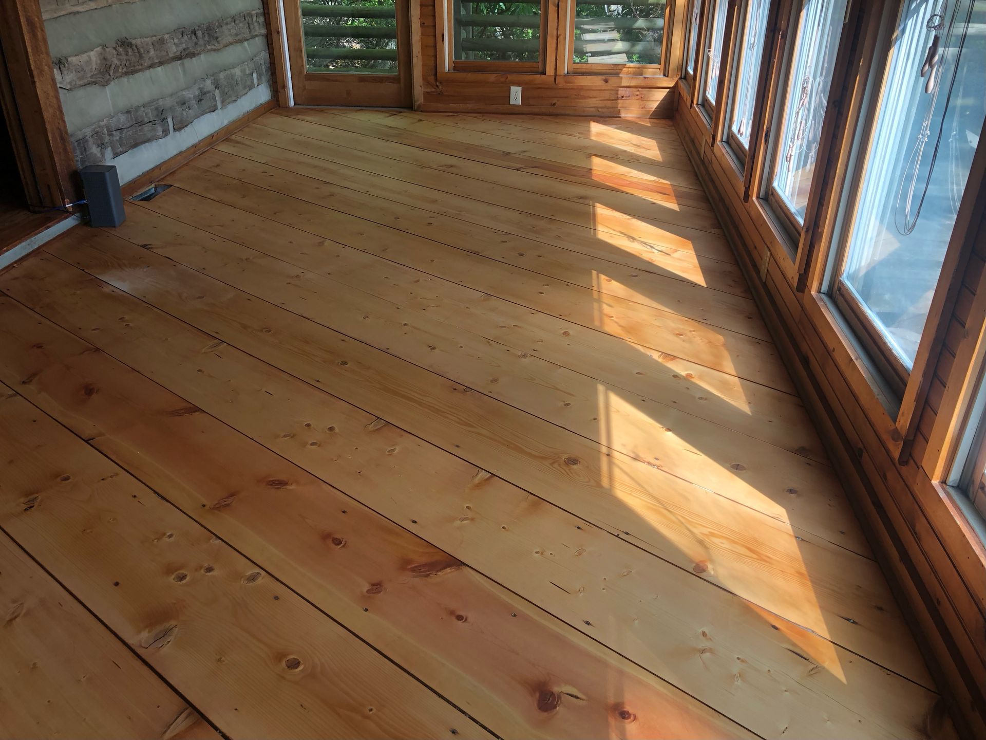 A sunroom in Boone, NC with refinished wood floors. After sanding.