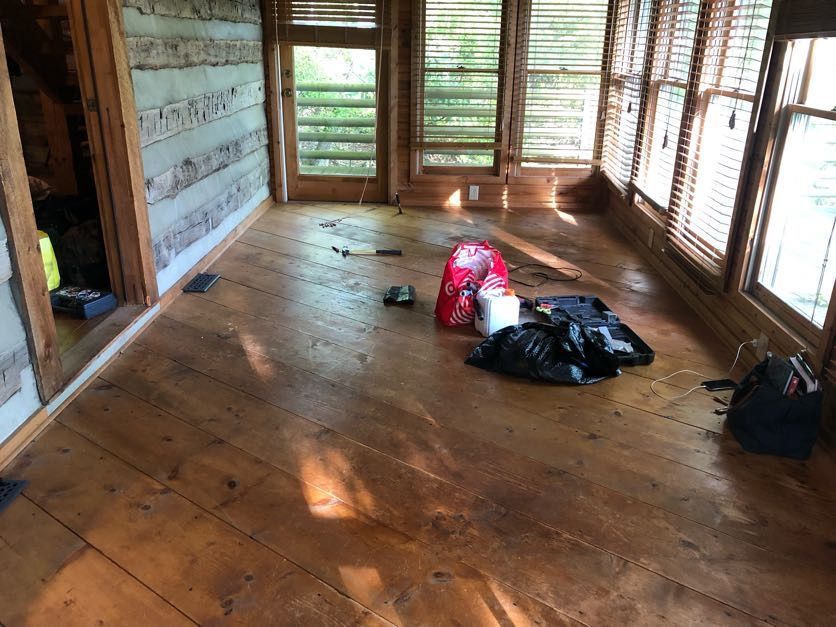 A sunroom in Boone, NC with refinished wood floors. Before sanding