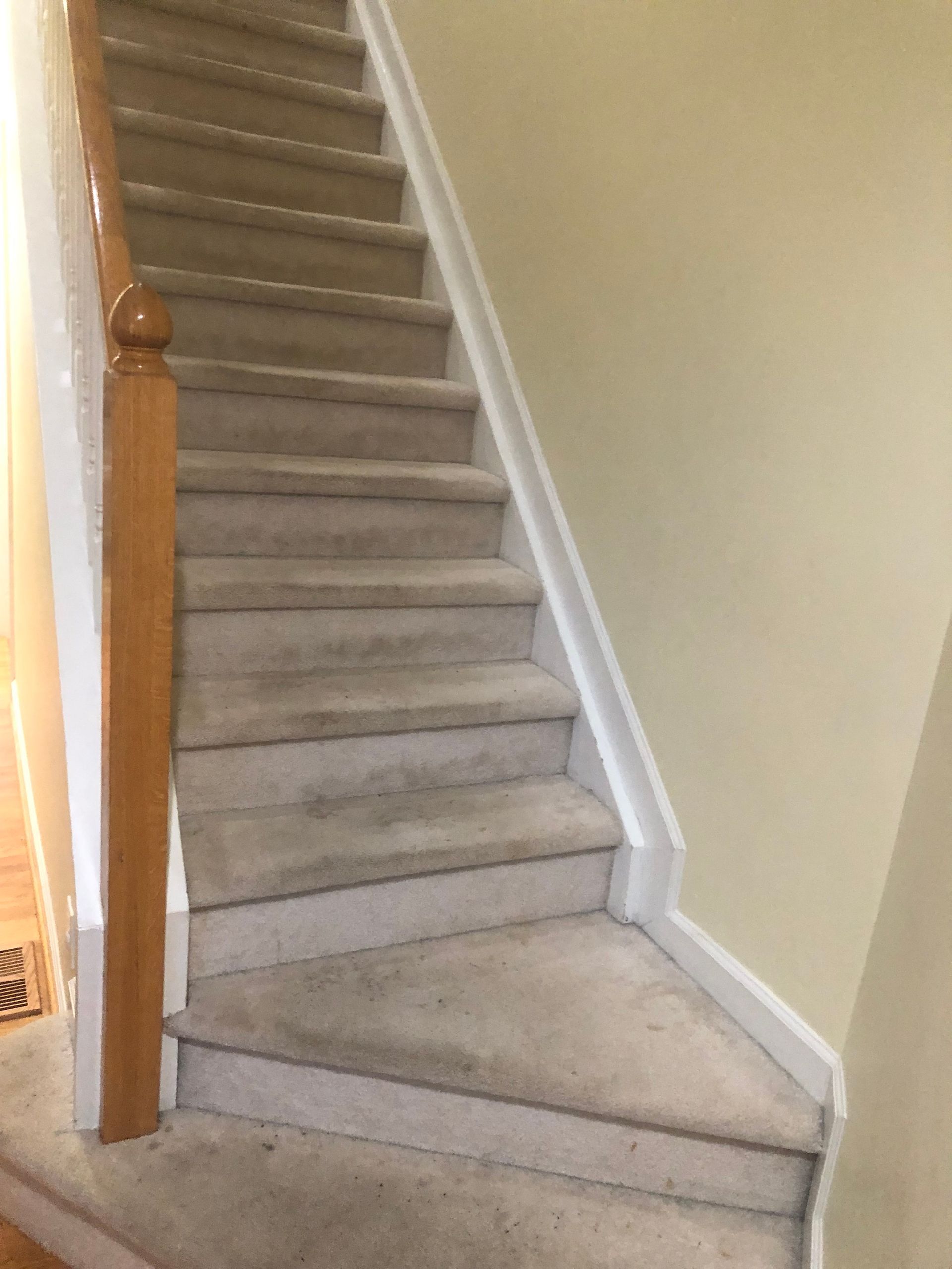 A staircase with carpeted steps and a wooden railing in a house.