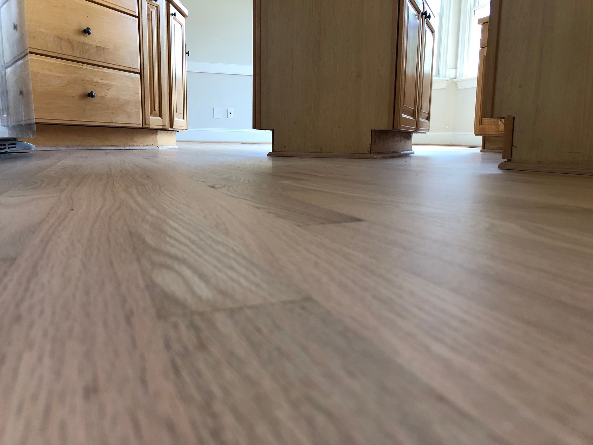A kitchen with wooden cabinets and a wooden floor