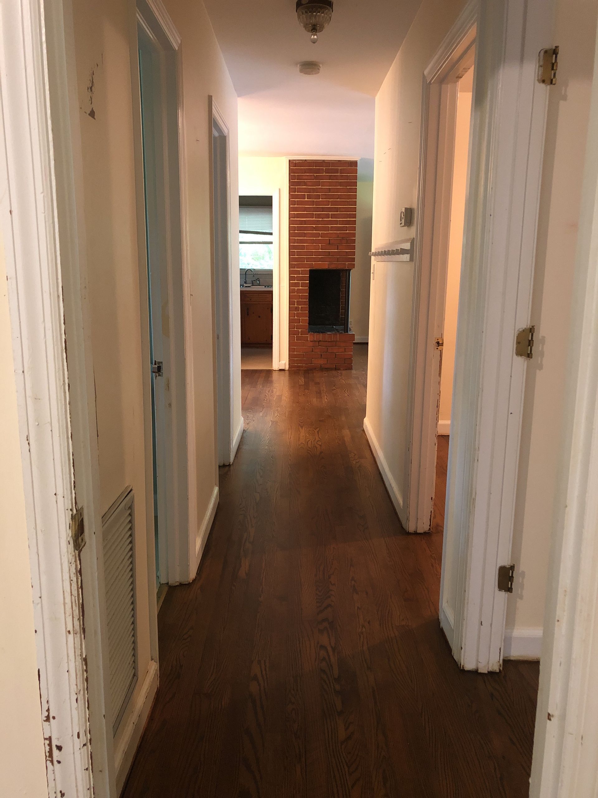 A long hallway with a fireplace in the middle of it.