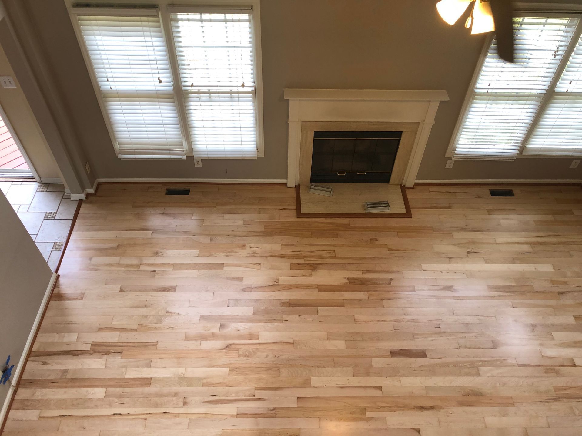 An aerial view of a living room with hardwood floors and a fireplace.