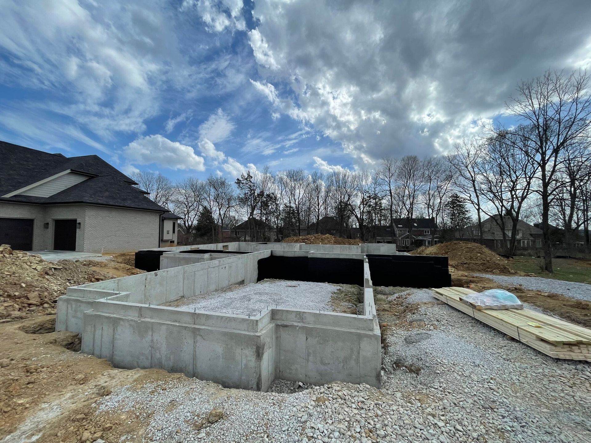 A concrete foundation is being built in front of a house.