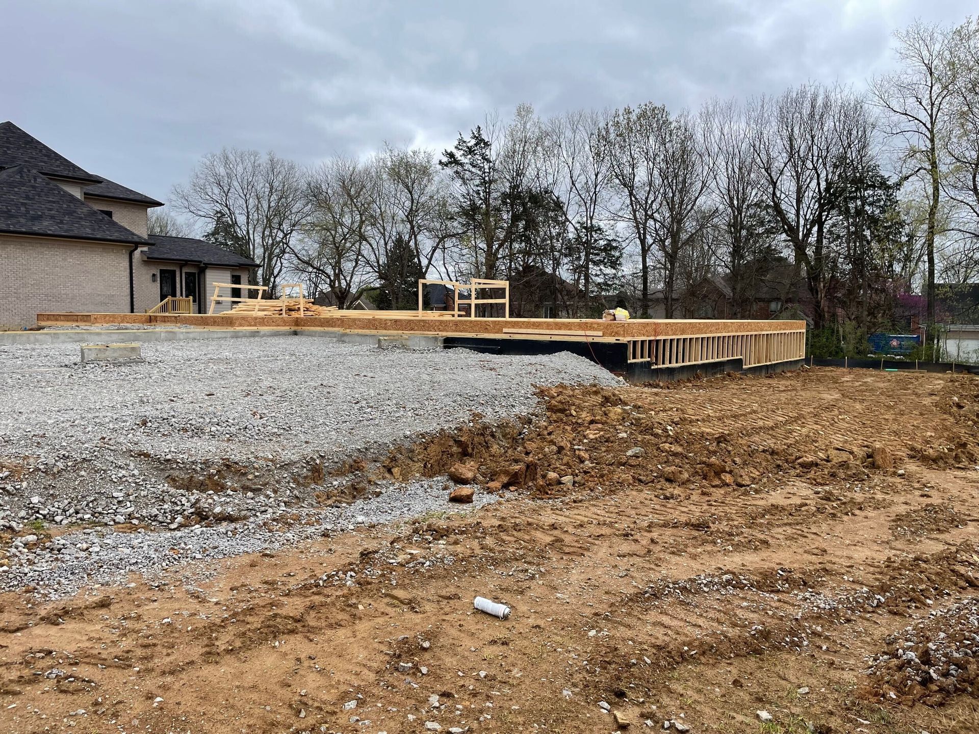 A house is being built in the middle of a dirt field.
