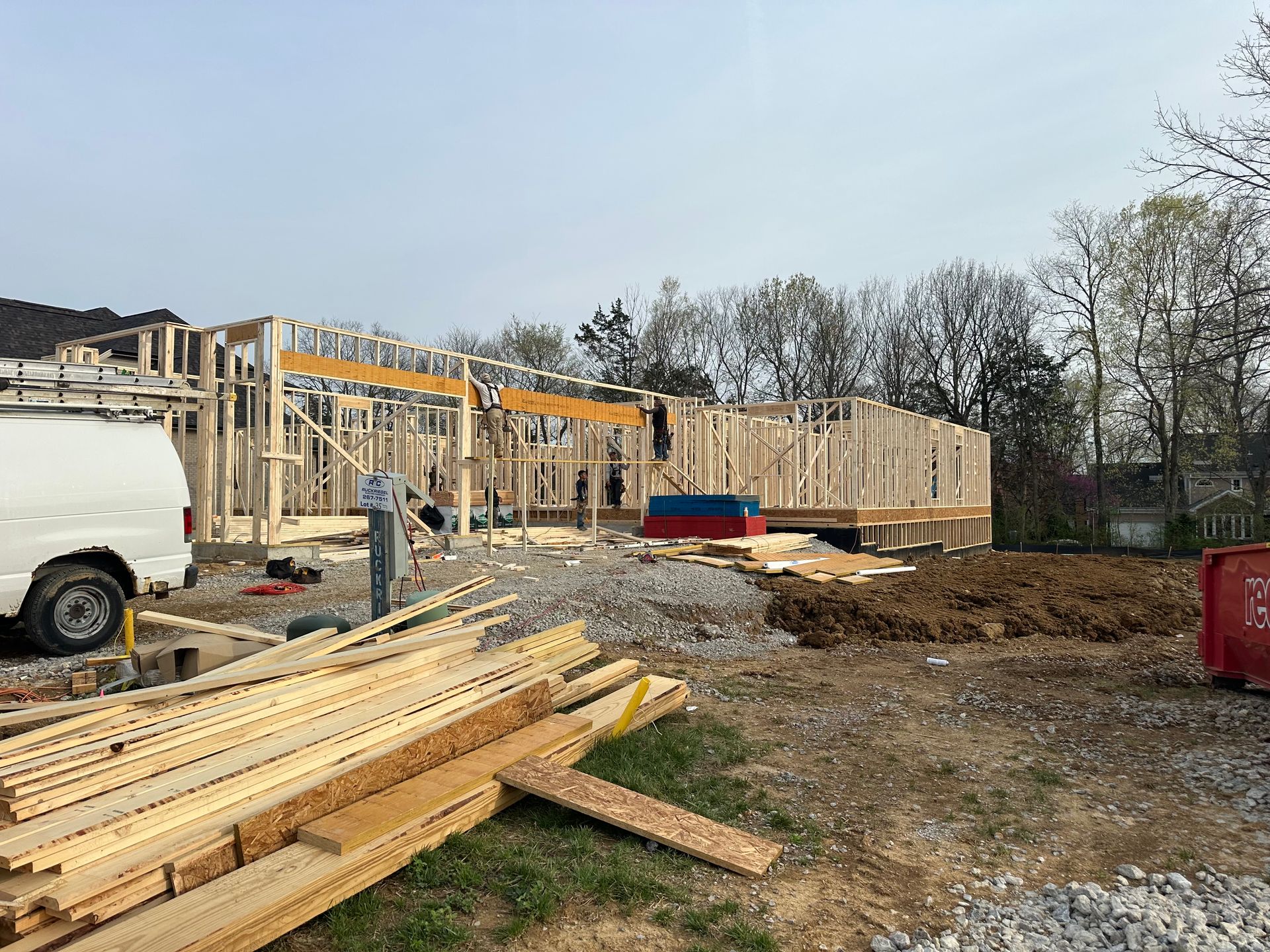 A white van is parked in front of a building under construction.