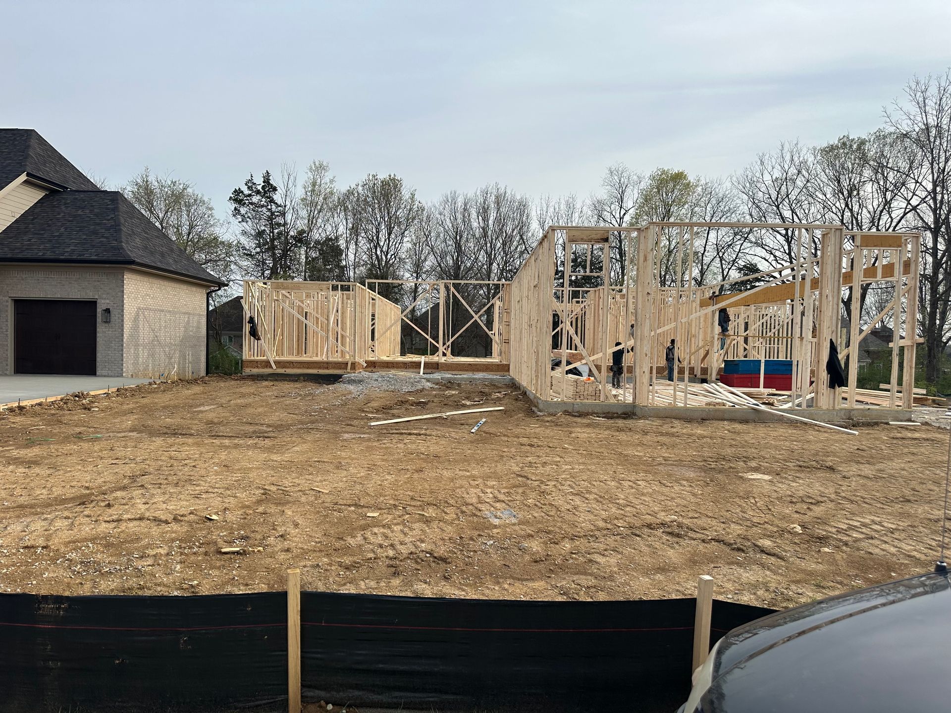 A house is being built in the middle of a dirt field.