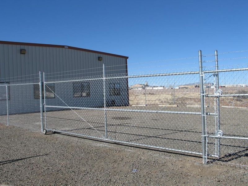 A chain link fence with a gate in front of a building