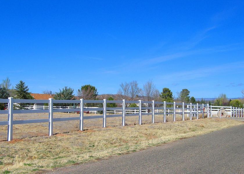 A white fence along the side of a road